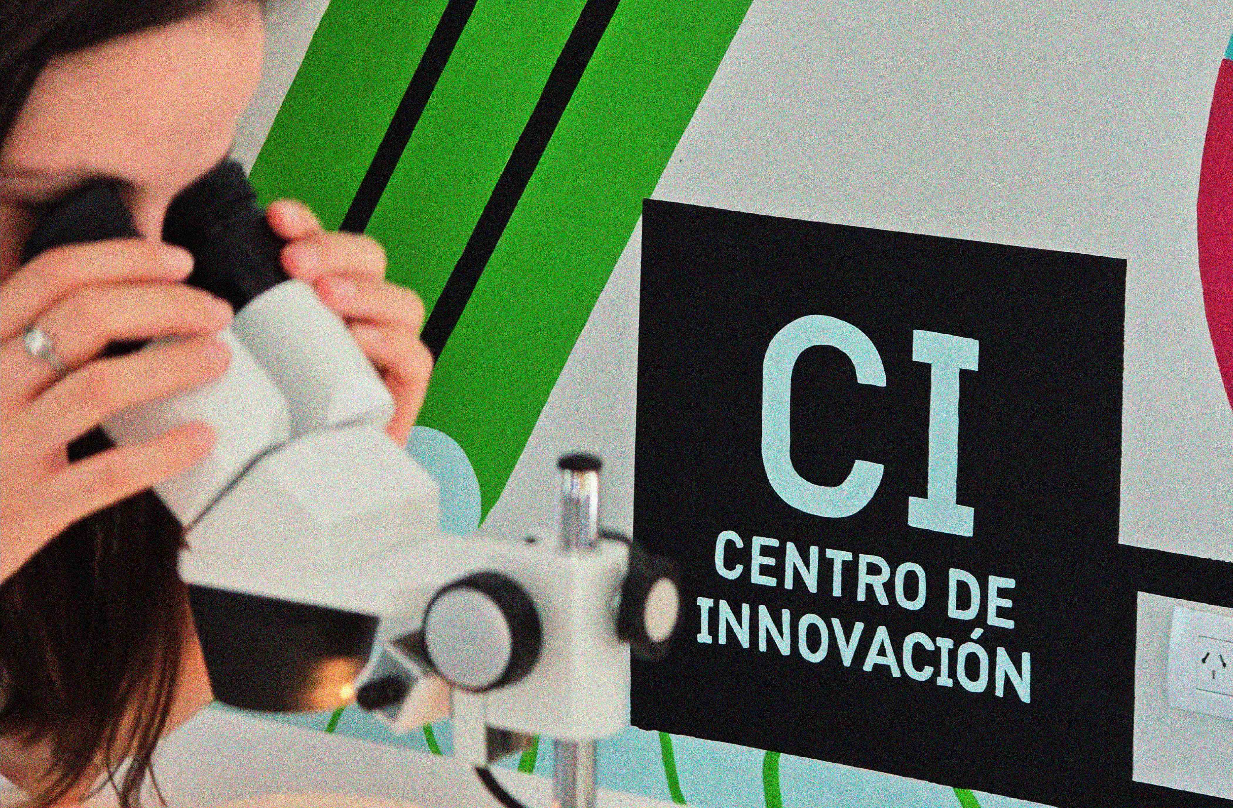 Centro de Innovación - Persona usando microscopio junto al mural