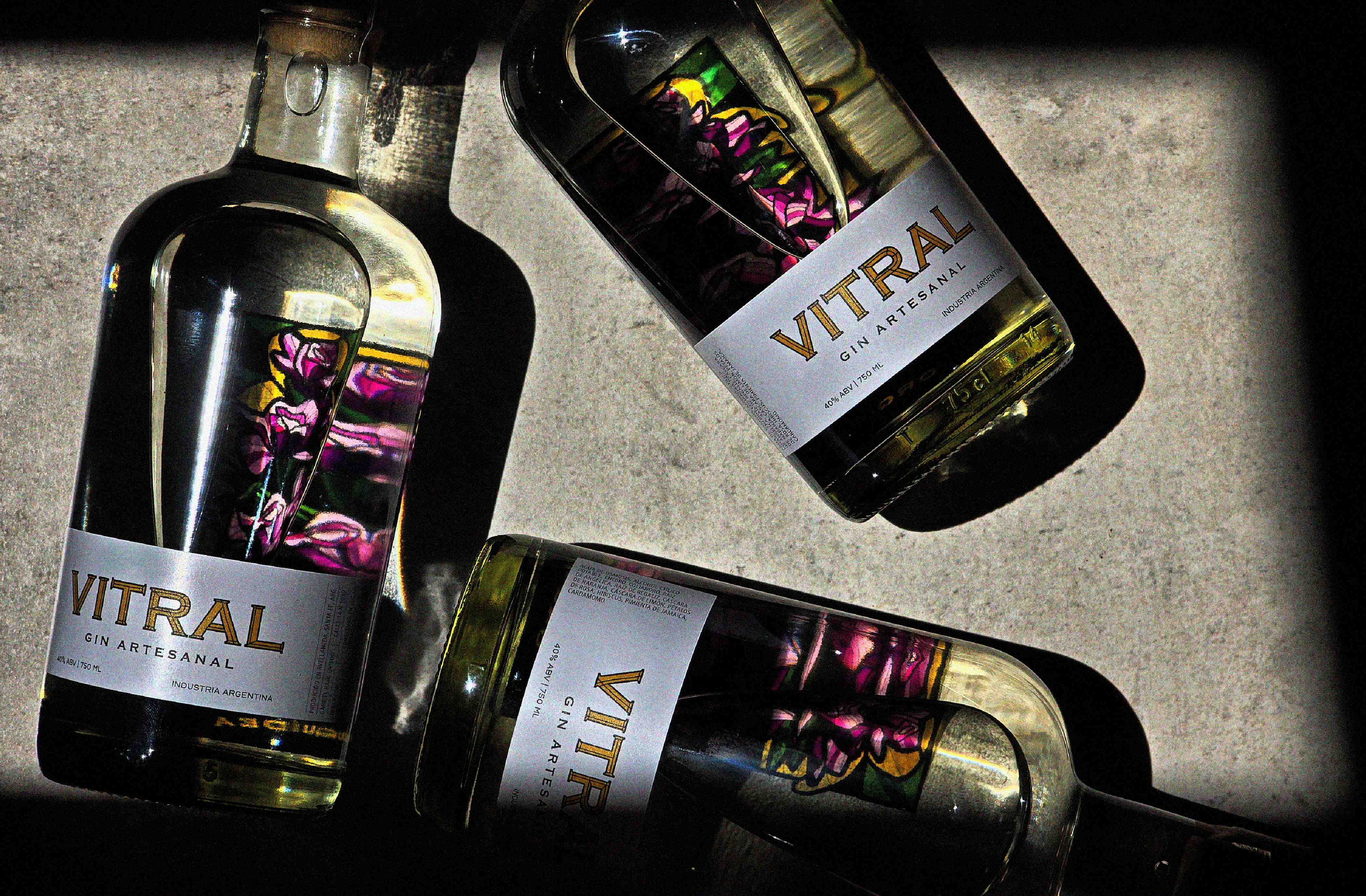Vitral - Tres botellas sobre superficie con sombras dramaticas